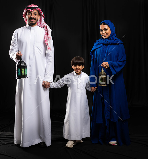 بورتريه لعائلة عربية خليجية سعودية ، فانوس رمضان ، الإستعداد لقدوم شهر رمضان المبارك ، المناسبات الدينية والأعياد الإسلامية ، رمضان كريم ، إسلاميات وعبادة ، خلفية سوداء ، صورة بالطول الكامل