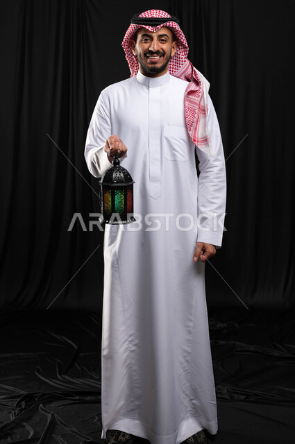 بورتريه لرجل عربي خليجي سعودي ، فانوس رمضان ، الإستعداد لقدوم شهر رمضان المبارك ، المناسبات الدينية والأعياد الإسلامية ، رمضان كريم ، إسلاميات وعبادة ، خلفية سوداء ، صورة بالطول الكامل