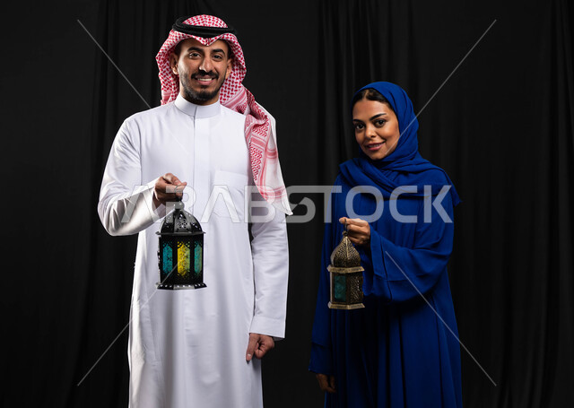 بورتريه لزوجان عربيان خليجيان سعوديان ، فانوس رمضان ، الإستعداد لقدوم شهر رمضان المبارك ، المناسبات الدينية والأعياد الإسلامية ، رمضان كريم ، إسلاميات وعبادة ، خلفية سوداء