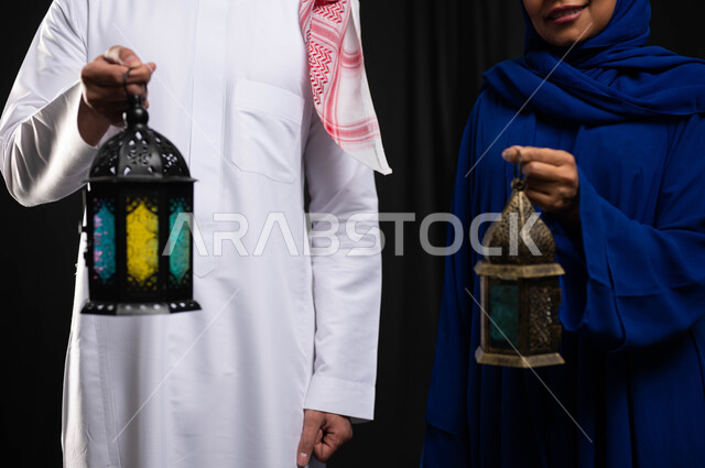 صورة مقربة لزوجان عربيان خليجيان سعوديان ، فانوس رمضان ، الإستعداد لقدوم شهر رمضان المبارك ، المناسبات الدينية والأعياد الإسلامية ، رمضان كريم ، إسلاميات وعبادة ، خلفية سوداء