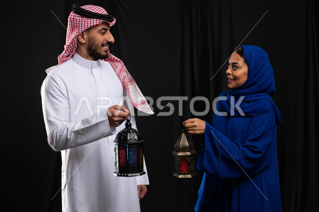 بورتريه لزوجان عربيان خليجيان سعوديان ، فانوس رمضان ، الإستعداد لقدوم شهر رمضان المبارك ، المناسبات الدينية والأعياد الإسلامية ، رمضان كريم ، إسلاميات وعبادة ، خلفية سوداء