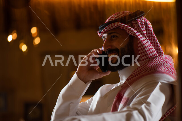 A Saudi Gulf Arab man making a phone call, communicating with individuals, communication and communication, social relations, chat and acquaintance, social communication, a Saudi session