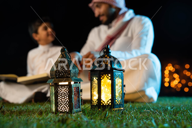 تصوير مقرب لرجل عربي خليجي سعودي وإبنه، قراءة القرآن الكريم، أدعية وأذكار، تلاوة وتحفيظ القرآن الكريم للأطفال، المناسبات الدينية والأعياد الإسلامية، فانوس رمضان، إستقبال شهر رمضان، زينة شهر رمضان، أجواء رمضانية، جلسات خارجية في الهواء الطلق
