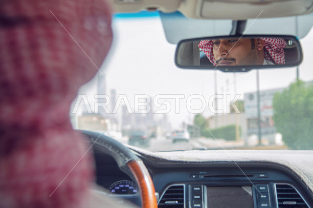 انعكاس على المرآة لصورة سائق عربي خليجي سعودي يقود سيارة الاجرة  ،خدمة توصيل الركاب ، خدمات النقل الامنة ، دروس القيادة ، التاكسي الاخضر في السعودية