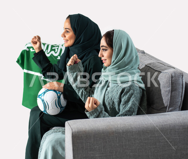 ايماءات يدين تدل على تمني الفوز للفريق ، مشاهدة ومتابعة مباريات كرة القدم ، الشغف بمباريات كرة القدم ، بورتريه من الجانب لأمرأتان عربيتان سعوديتان خليجيتان  ترتديان العباءه الخليجية ، تشجيع الفريق الأهلي السعودي والمنتخب السعودي أنديه وتشجيع ، خلفية بيضاء