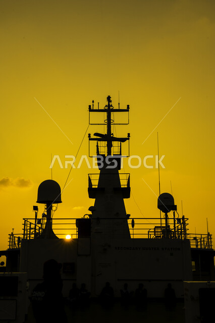 Silhouette of a group of people on the deck of a steamship, sunset, marine transportation
