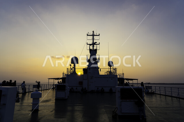 Group of people on the deck of a ship, sunset, marine transportation, cruise ships