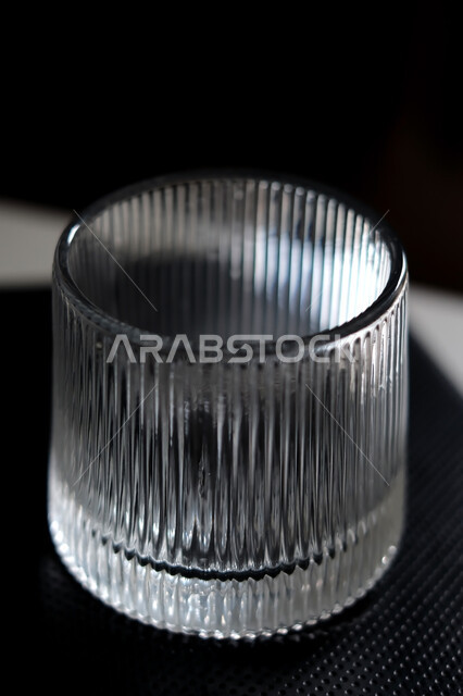 كوب زجاجي فارغ على خلفية سوداء , كأس كريستال , كوب ماء شفاف . 