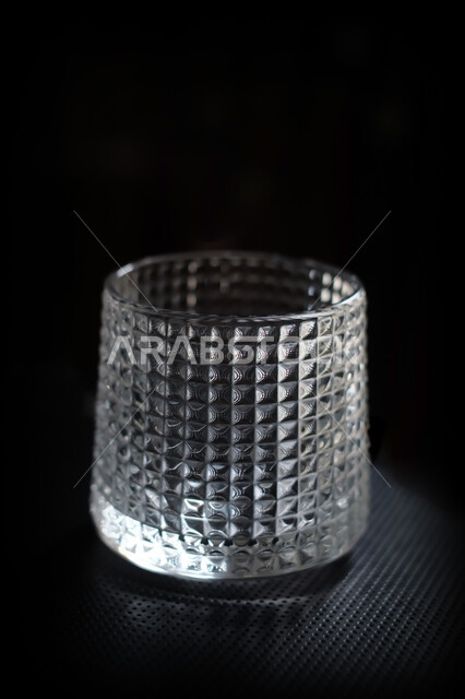 كوب زجاجي فارغ على خلفية سوداء , كأس كريستال , كوب ماء شفاف . 