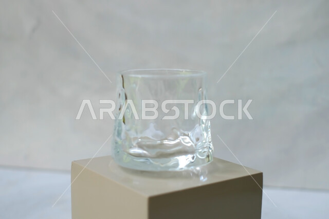 كوب زجاجي فارغ على خلفية بيضاء , كأس كريستال , كوب ماء شفاف , قاعدة عرض المنتجات . 