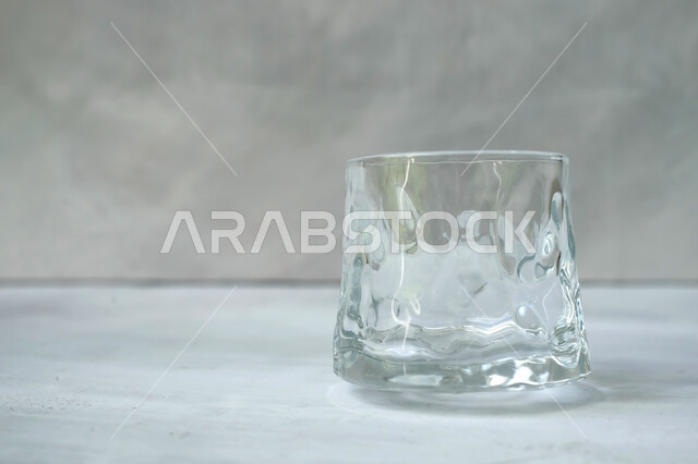 كوب زجاجي فارغ على خلفية بيضاء , كأس كريستال , كوب ماء شفاف , قاعدة عرض المنتجات . 