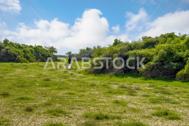 ولد عربي خليجي قطري يتجول في محمية الريم شمال قطر، محمية طبيعية، الاشجار والنباتات الخضراء، الطبيعة الخضراء، خلفية الطبيعة