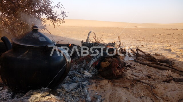 صوره مقربه لإبريق شاي على الحطب,رحلة تخييم  في الصحراء ، الطبيعة الصحراويه ، جلسة بر عربية شعبية , مخيم شعبي, خلفية الطبيعة. 