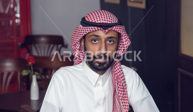 رجل عربي سعودي خليجي يجلس في المقهى, قضاء وقت هادئ في المتجر, مفهوم الترفيه الفردي, تأمل وتفكر, إسترخاء وراحه, قضاء وقت ممتع خارج المنزل, مقاهي في المملكه العربيه السعوديه