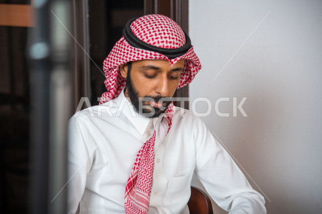 رجل عربي سعودي خليجي يجلس في المقهى, قضاء وقت هادئ في المتجر, مفهوم الترفيه الفردي, تأمل وتفكر, إسترخاء وراحه, قضاء وقت ممتع خارج المنزل, مقاهي في المملكه العربيه السعوديه