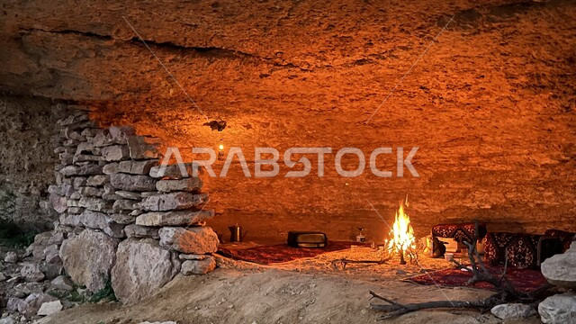 صورة من داخل مغارة حجرية، كهف اثري قديم، شعلة الحطب، شبة نار، رحلة برية، كشتة بر، جلسة بر عربية شعبية