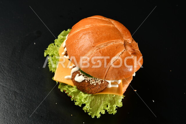 صورة مقربة لساندوتش البرجر باللحم، وجبة غذائية شهية ، تقديم الوجبات السريعة، وجبة الهمبرجر اللذيذة، مطاعم ومأكولات