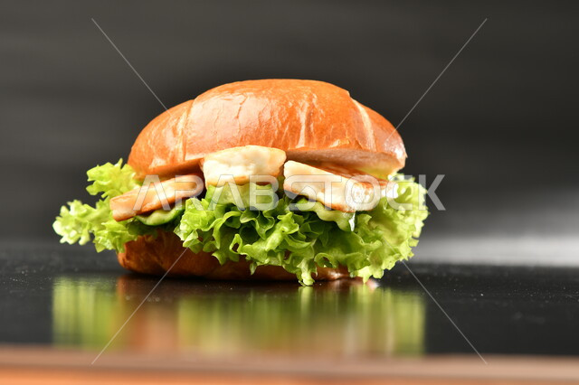 صورة مقربة لساندوتش البرجر باللحم، وجبة غذائية شهية ، تقديم الوجبات السريعة، وجبة الهمبرجر اللذيذة، مطاعم ومأكولات