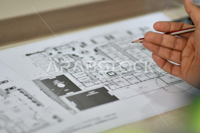 Close up of architect hand holding pen, design map, engineering project management, engineering concept, blueprints and engineering designs