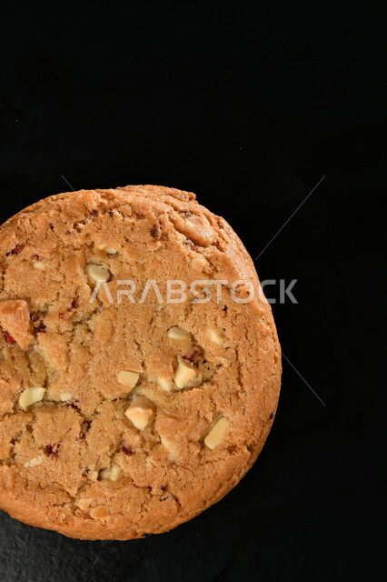 صورة من الاعلى لرقائق الكوكيز المقرمش، رقاقات البسكويت الهشة، كوكيز، حلويات مخبوزة طازجة، خلفية سوداء