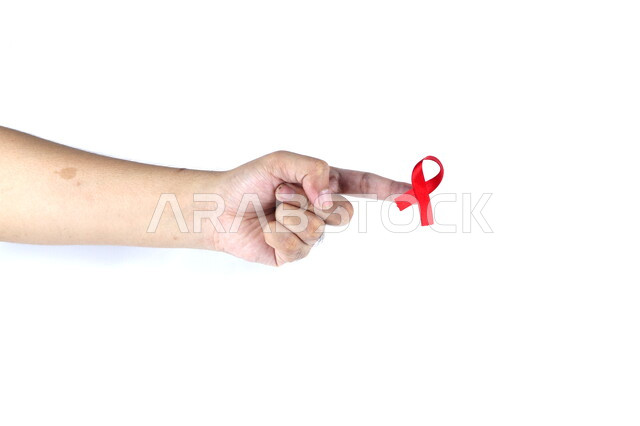 يد تمسك شريط أحمر , شريط التوعية بمرض الإيدز , نقص المناعة البشرية , رعاية صحية , خلفية بيضاء .
