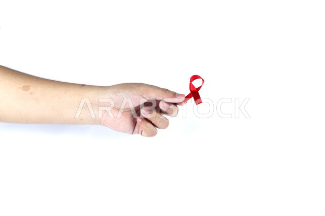 يد تمسك شريط أحمر , شريط التوعية بمرض الإيدز , نقص المناعة البشرية , رعاية صحية , خلفية بيضاء .
