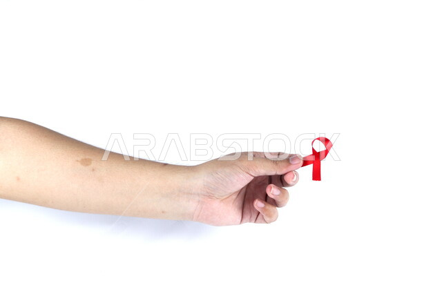 يد تمسك شريط أحمر , شريط التوعية بمرض الإيدز , نقص المناعة البشرية , رعاية صحية , خلفية بيضاء .