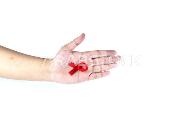 يد تمسك شريط أحمر , شريط التوعية بمرض الإيدز , نقص المناعة البشرية , رعاية صحية , خلفية بيضاء .