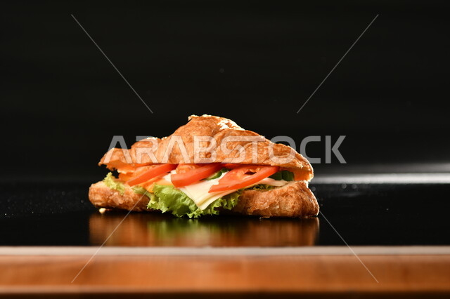 Close-up of delicious chicken sandwich with cut vegetables, delicious food recipes, fast food meals, Arabic restaurants, black background