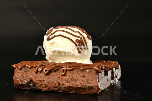 صورة مقربة لقطعة من الكيك المزينة بالشوكلاتة، حلوى البوظة، ايس كريم، حلا شرقي، حلويات وسكريات، التحلاية، حلويات شهية، حلويات صيفيه باردة، خلفية سوداء