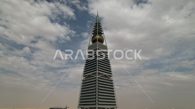 صورة من الاسفل لبرج الفيصلية في الرياض بالمملكة العربية السعودية ليلا، ابراج مدينة الرياض، أبراج وناطحات سحاب مضيئة، الفن الهندسي المعماري بالسعودية، معالم الرياض المشهورة خلفية السماء .