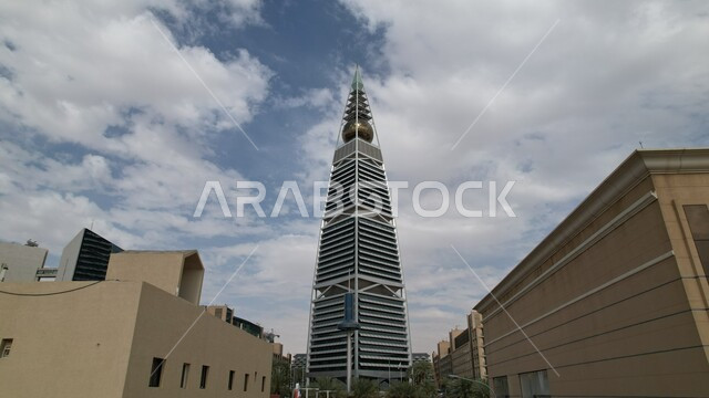 صورة من الاسفل لبرج الفيصلية في الرياض بالمملكة العربية السعودية ليلا، ابراج مدينة الرياض، أبراج وناطحات سحاب مضيئة، الفن الهندسي المعماري بالسعودية، معالم الرياض المشهورة خلفية السماء .