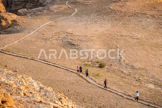 مجموعة من الشباب العرب الخليجيين السعوديين يمارسون رياضة الهايكينج في منطقة جبال طويق بالمملكة العربية السعودية، المشي في الصحراء، جبال طويق، قمم جبلية، حجارة وصخور جبلية، صحة ولياقة بدنية