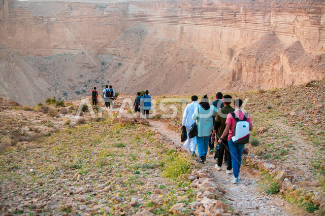 مجموعة من الشباب العرب الخليجيين السعوديين يمارسون رياضة الهايكينج في منطقة جبال طويق بالمملكة العربية السعودية، المشي في الصحراء، جبال طويق، قمم جبلية، حجارة وصخور جبلية، صحة ولياقة بدنية