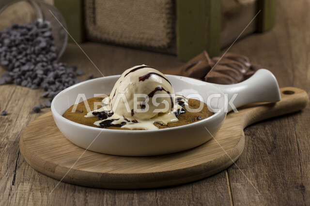 طبق من حلا كيك الشوكولاته المزينة بقطعة آيس كريم بنكهة الفانيليا ، حلا شرقي ، حلويات وسكريات ، قطع الحلوى الشهية ، التحلاية ، حلويات باردة لذيذة .