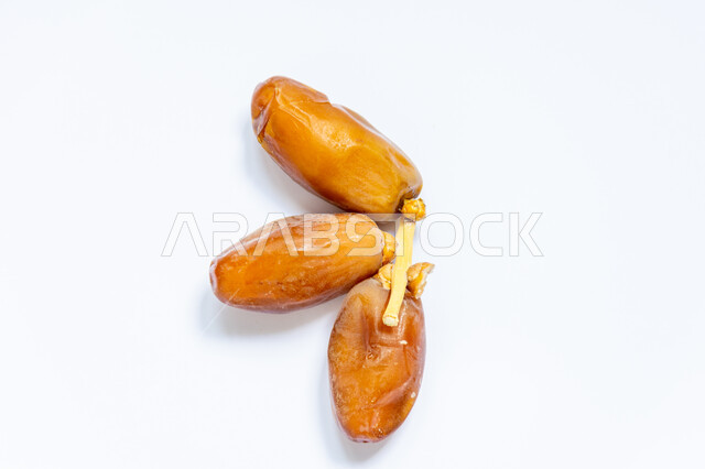 حبات التمر الصحي معزولة على خلفية بيضاء ، تمر دقلة نور ، ضيافة رمضانية ، التمور ، وجبة ذات قيمة غذائية