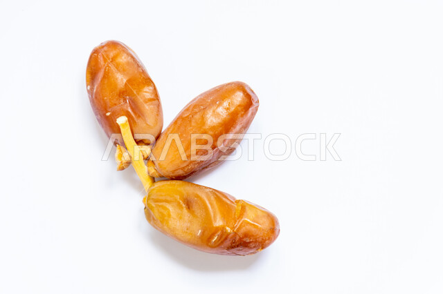 حبات التمر الصحي معزولة على خلفية بيضاء ، تمر دقلة نور ، ضيافة رمضانية ، التمور ، وجبة ذات قيمة غذائية