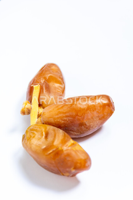 حبات التمر الصحي معزولة على خلفية بيضاء ، تمر دقلة نور ، ضيافة رمضانية ، التمور ، وجبة ذات قيمة غذائية