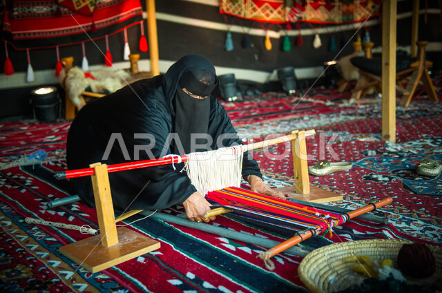 سيدة عربية خليجية تقوم بحياكة و غزل السدو على آلة النول ( السدو ) ، نسج ...