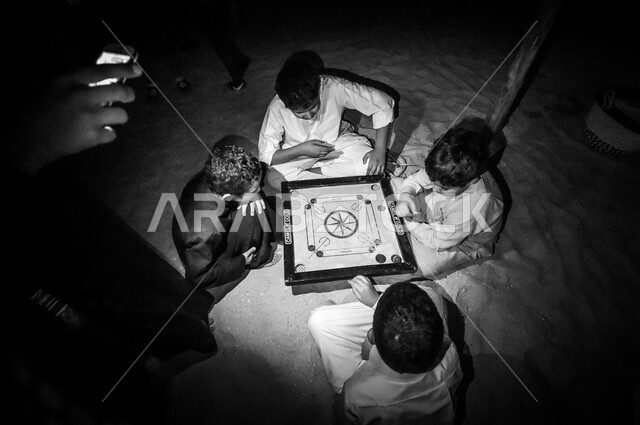 مجموعة الأصدقاء العرب القطريين يلعبون لعبة مجلس كاروم ، تحدي الأصدقاء ، التسليه والترفيه ، نشاطات ترفيهية  تحديات ومنافسات ، صورة بالأبيض والأسود