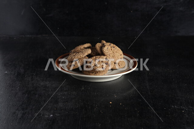 طبق من رقائق الكوكيز المقرمش، رقاقات البسكويت الهشة، كوكيز، حلويات مخبوزة طازجة، خلفية سوداء