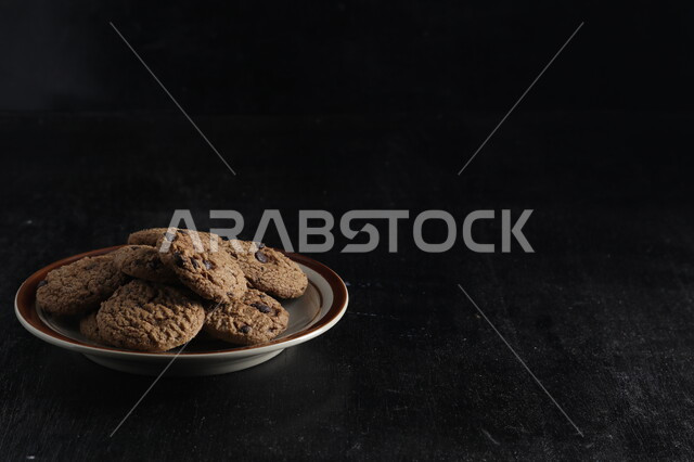 طبق من رقائق الكوكيز المقرمش، رقاقات البسكويت الهشة، كوكيز، حلويات مخبوزة طازجة، خلفية سوداء