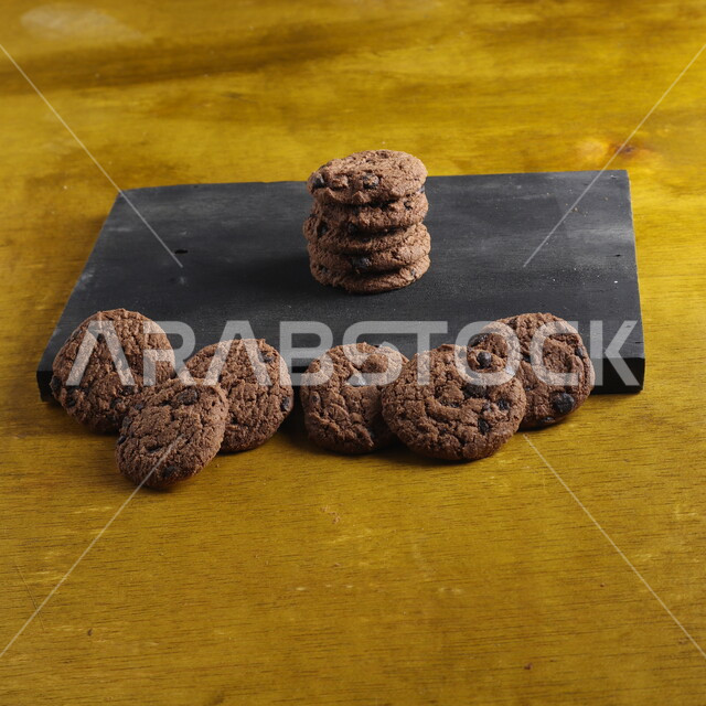  رقائق الشوكولاتة الساخنة  ، رقاقات البسكويت  مع كرات من الشوكولاتة الداكنة  ، كوكيز ، بسكويت ، حلويات مخبوزة , خلفيات بنية  .