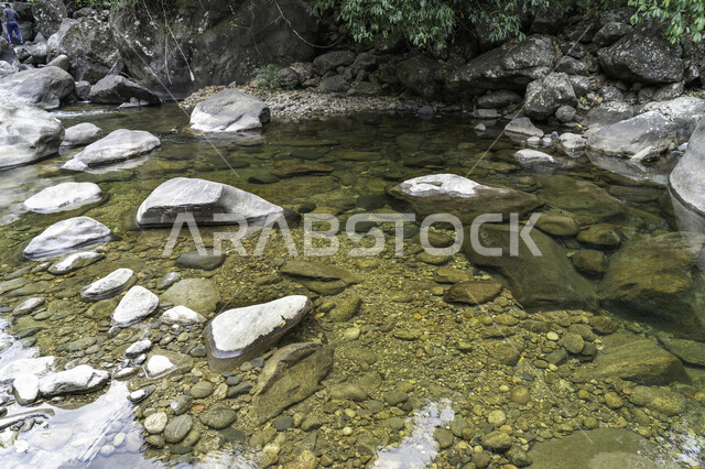 Close-up of underwater rocks, water stream surrounded by rocks, water flowing over rocks, natural background, landscape