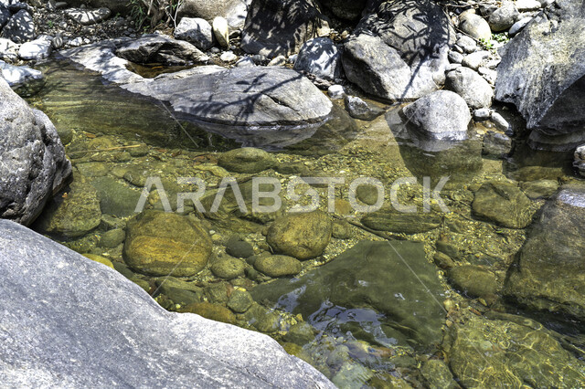 Close-up of underwater rocks, landscape, water flowing on rocks, natural background, water current
