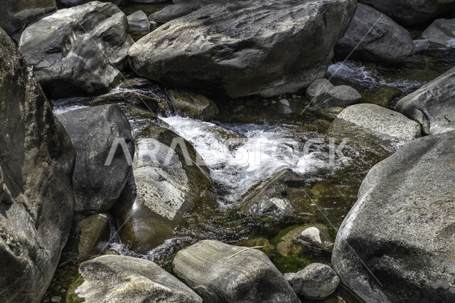 صورة مقربة لصخور ينبع من بينها الماء , مناظر طبيعية , جريان الماء على الصخور , تيار مائي , خلفية طبيعية