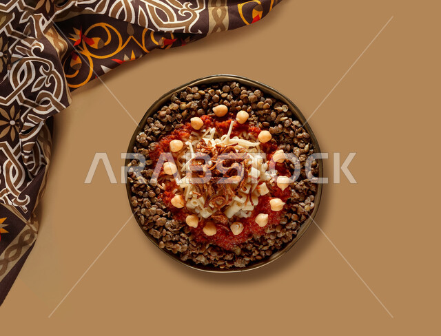 طبق من الكشري المصري الشهير ، أطباق شعبية تقليدية ، مائدة طعام ، مطاعم عربية شرقية ، وصفات مصرية , خلفية بنية .