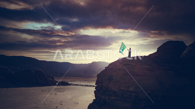 التكوينات والتشكيلات الصخرية الطبيعية في مدينة العلا في المملكة العربية السعودية ، رجل يمسك علم السعودية , المعالم التاريخية الأثرية السياحية، الطبيعة الصحراوية و الجبال الصخرية ، السياحة في السعودية .