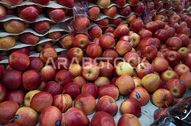 Close-up of the red apple fruit inside the supermarket, buying household needs, various goods and foodstuffs, consumer supplies, shops.