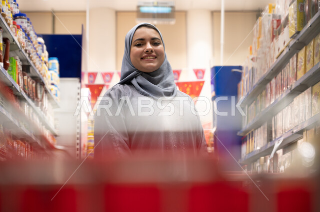صورة مقربة امرأة عربية خليجية داخل السوبرماركت ، قضاء وقت ممتع بالتسوق ، منتجات غذائية  ، احتياجات  المستهلك.